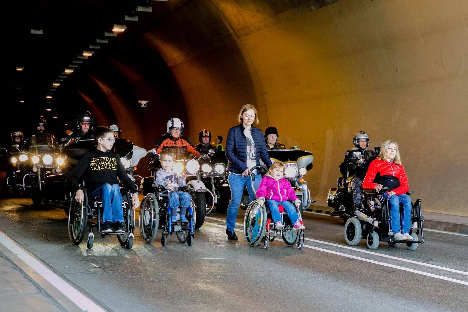 Harley-Davidson riders escort wheelchair users on a charity tour.