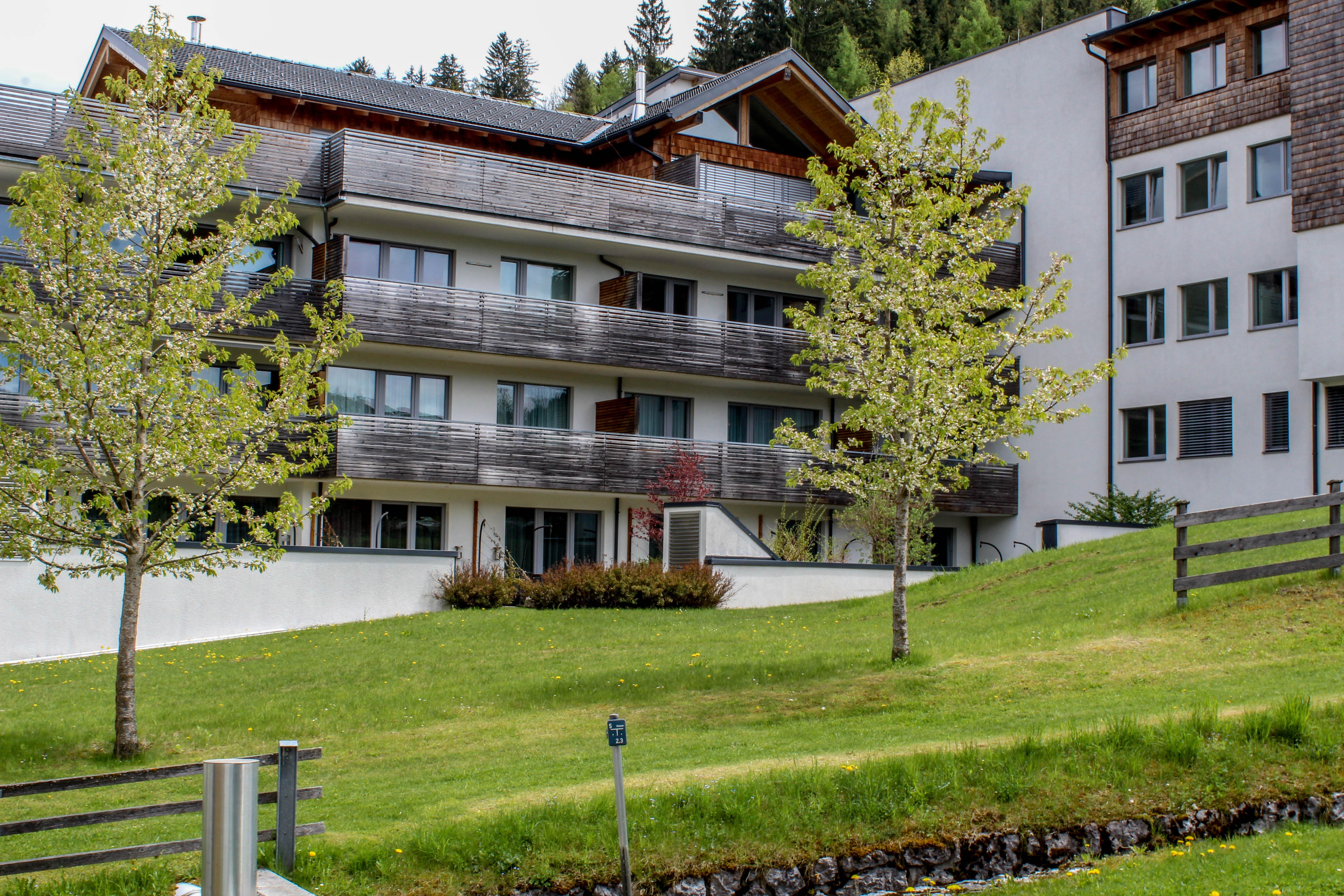 Grüne Rasenfläche und die SissiPark-Apartments.